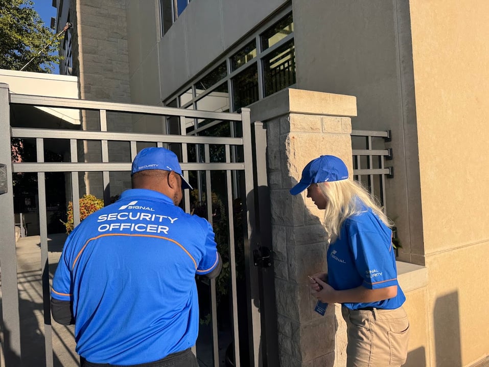 Two Signal of Lincoln security officers checking a gate on foot during a mobile patrol in Lincoln, NE