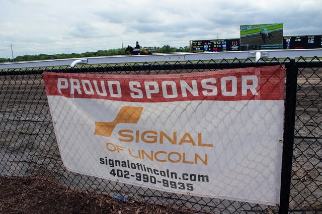 Signal of Lincoln Proud Sponsor banner on the rail at Legacy Downs during a live race