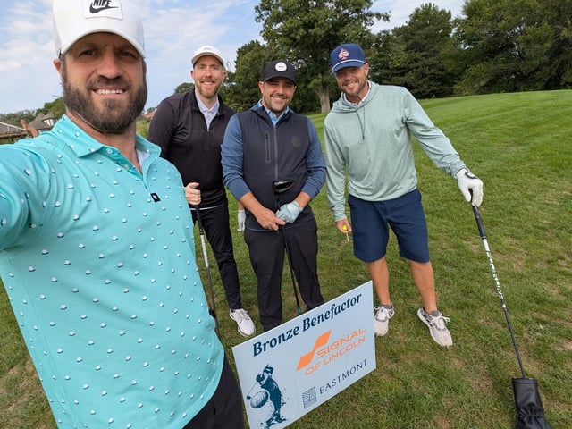 Troy Nielsen with his foursome next to the Signal of Lincoln Bronze Benefactor sign at the 2025 Eastmont golf tournament